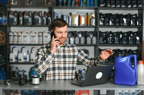 Personne comparant des pièces auto sur un ordinateur et dans un magasin physique montage