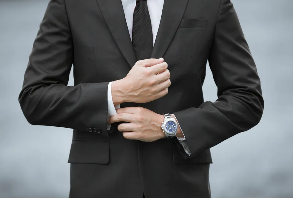 Mężczyzna w garniturze z kwadratowym zegarkiem na bransolecie