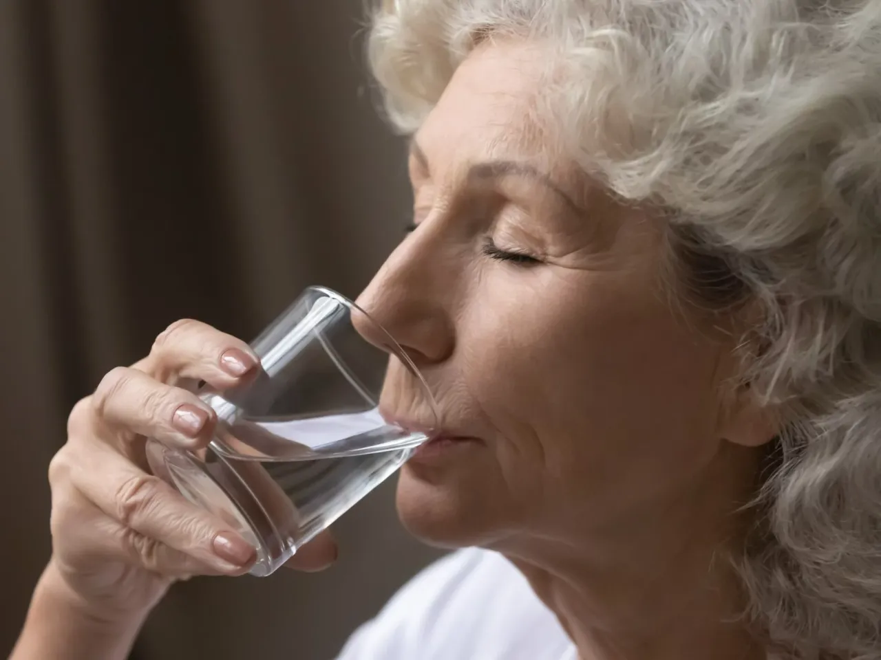 Senior pije wodę, osoba starsza nawadnianie