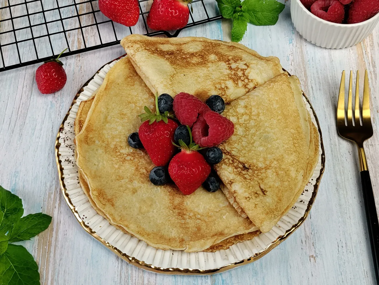 Delikatne naleśniki keto z mąki migdałowej, udekorowane świeżymi truskawkami, malinami i borówkami. Idealne na zdrowy deser.