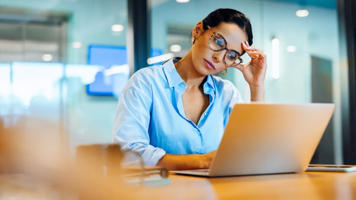 osoba pracująca przy komputerze w okularach filtrujących światło niebieskie