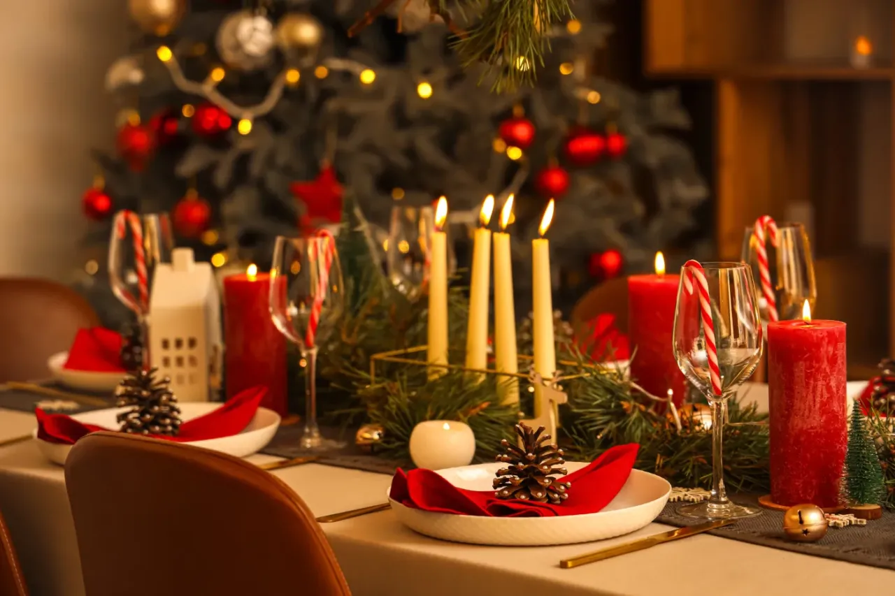 Elegancko nakryty stół na Wigilię w restauracji, z choinką w tle. Zastanawiasz się, ile kosztuje wigilia w restauracji?