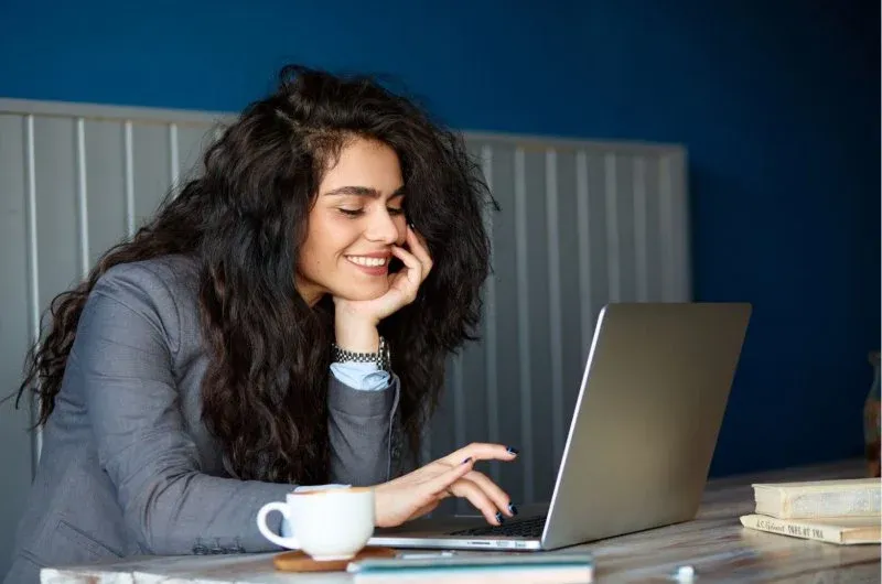 młoda osoba szukająca praktyk zawodowych laptop