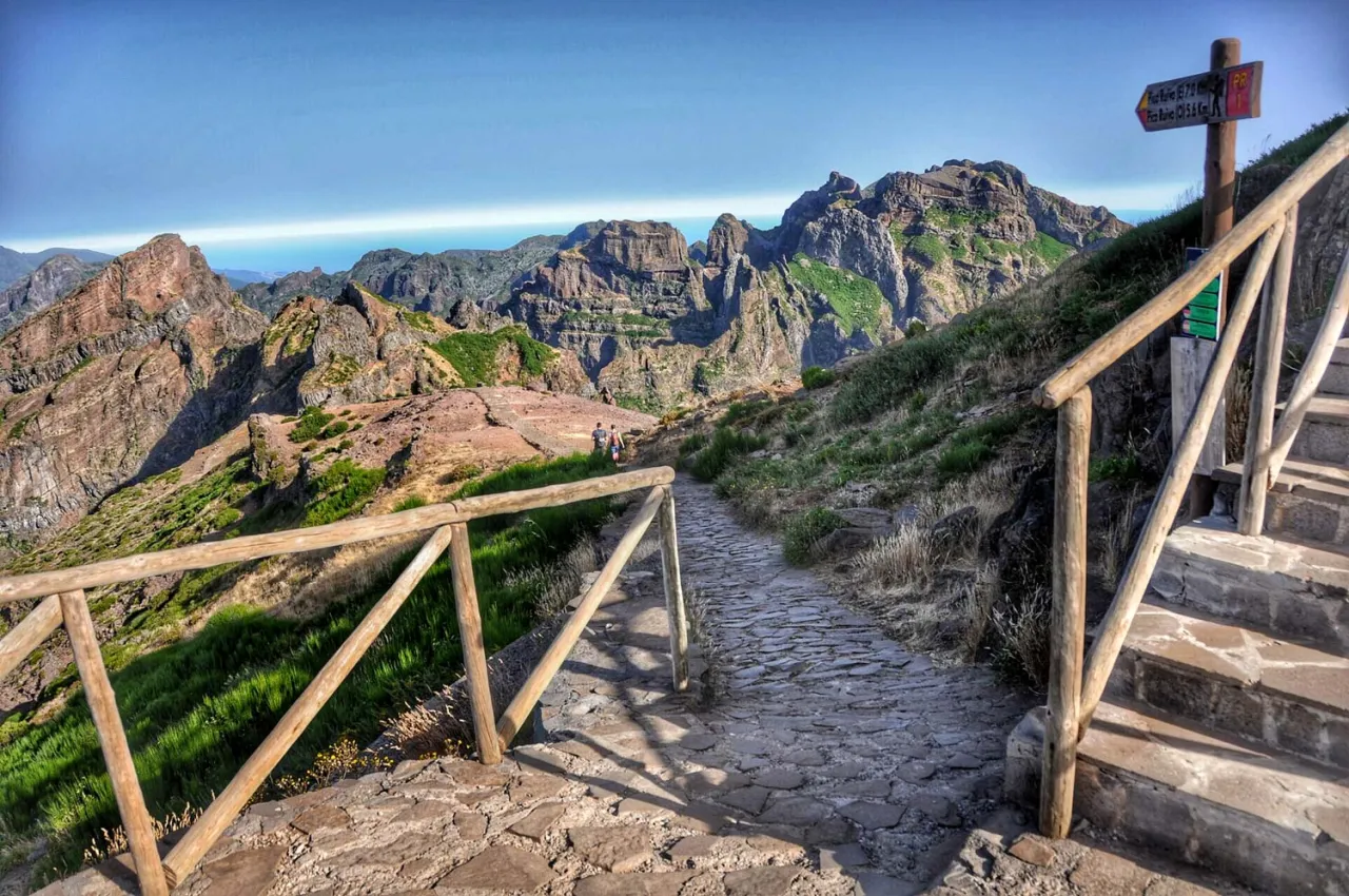 Kamienista ścieżka prowadzi przez górzysty krajobraz Madery, oferując widok na skaliste szczyty i ocean. To jedne z najpiękniejszych szlaków trekkingowych na Maderze, łączące lewady i wspinaczki na szczyty.