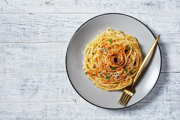 plato de espaguetis con anchoas y pan rallado tostado