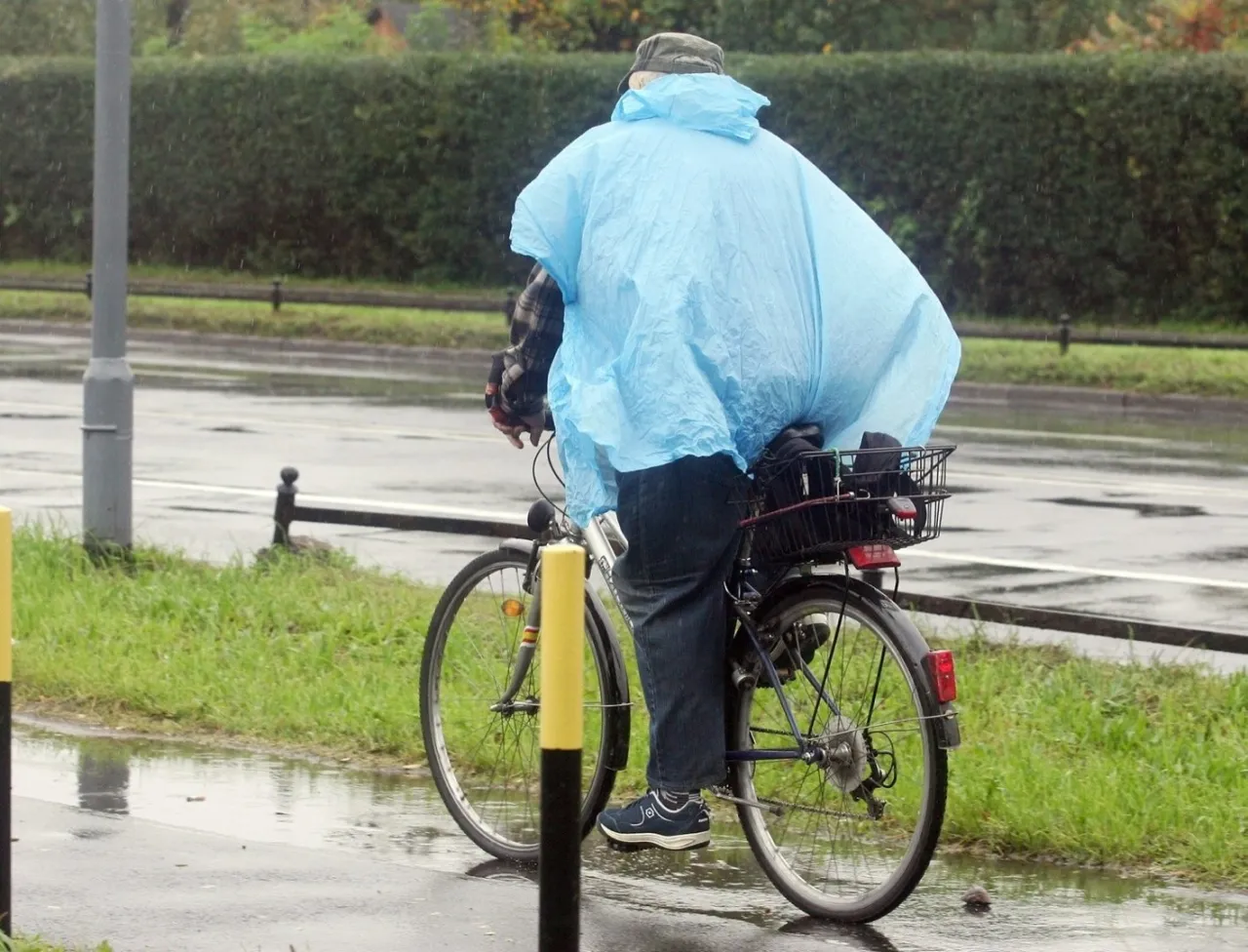 Rowerzysta na chodniku w trudnych warunkach pogodowych