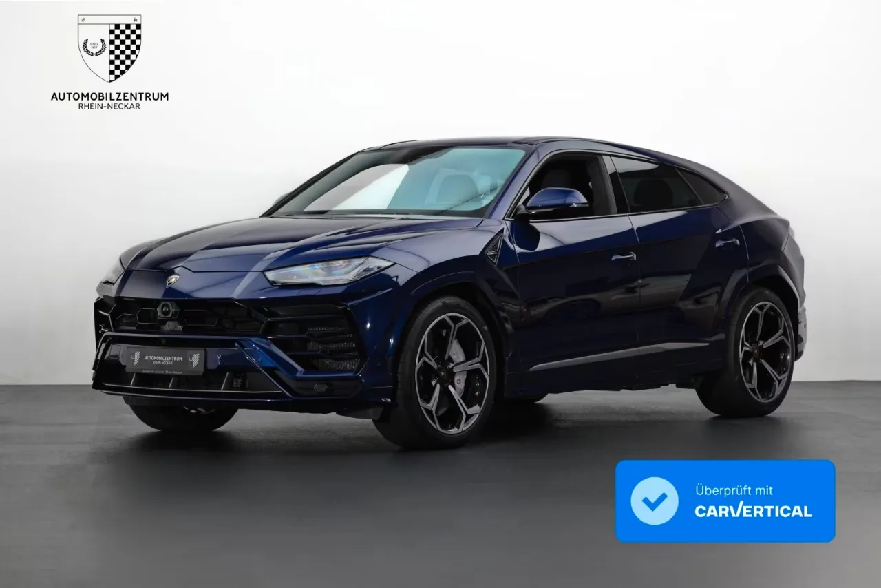 Ciemnoniebieski Lamborghini Urus na tle białej ściany. Zastanawiasz się, ile kosztuje Lamborghini Urus?