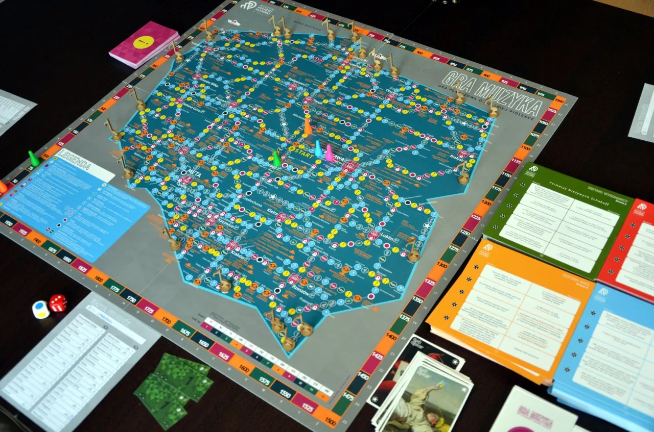 Jaka to melodia gra planszowa z mapą Polski i symbolami muzycznymi. Gracze poruszają się po planszy, odwiedzając miasta i festiwale muzyczne.