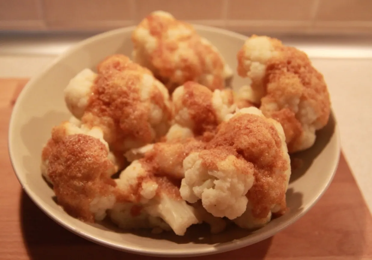 Gotowany mrożony kalafior w przyprawach na talerzu. Dowiedz się, ile gotować mrożony kalafior, by był idealny.