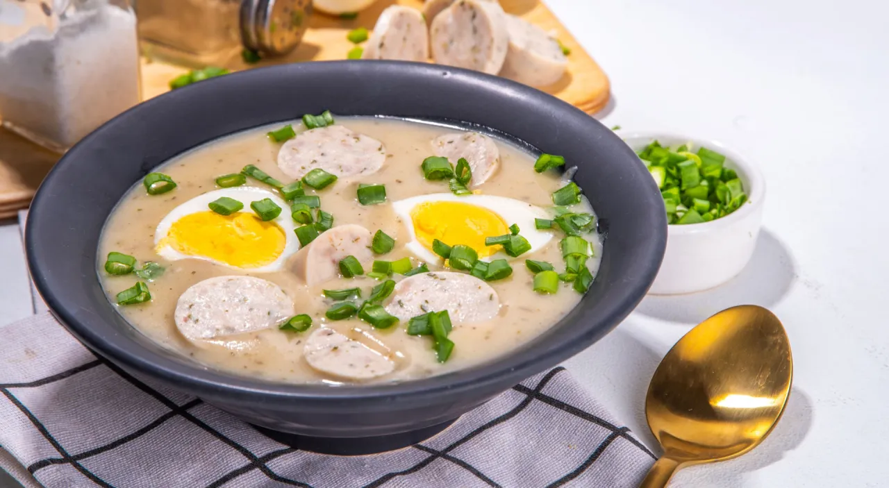 Żurek na zakwasie czy barszcz biały? Ta zupa z białą kiełbasą i jajkiem, posypana szczypiorkiem, wygląda pysznie.
