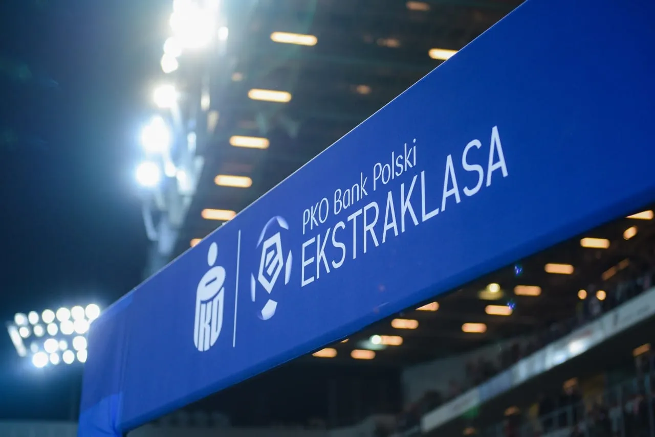 Niebieski baner z logo PKO Bank Polski Ekstraklasa na tle rozświetlonego stadionu. To prawdziwy skarb kibica, kt&oacute;ry czeka na emocje!