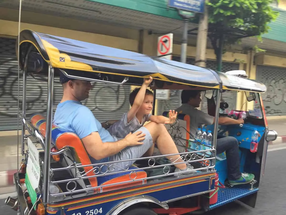 Rodzina cieszy się przejażdżką tuk-tukiem, doświadczając autentycznego transportu w Bangkoku.