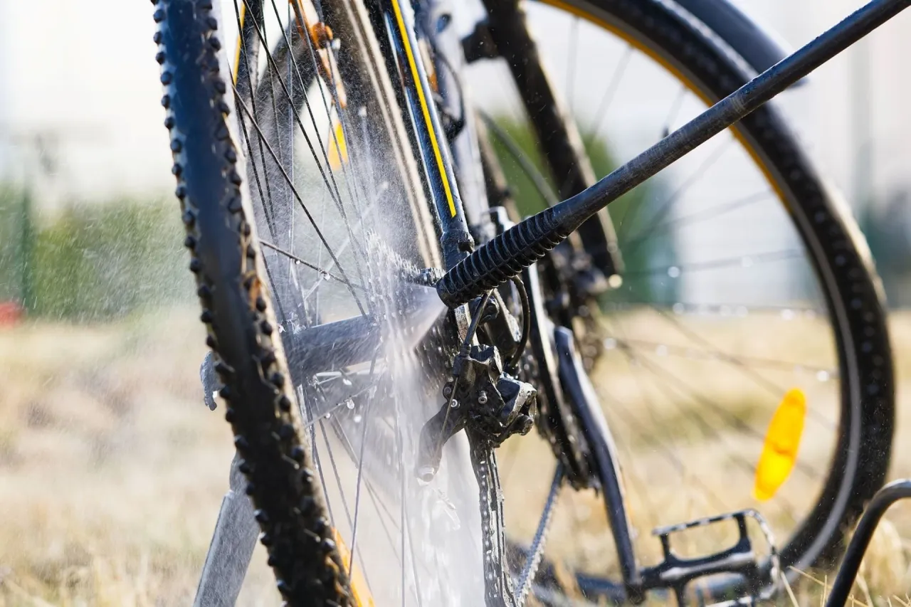 Mycie roweru Karcherem &ndash; strumień wody spłukuje błoto z łańcucha i przerzutek.