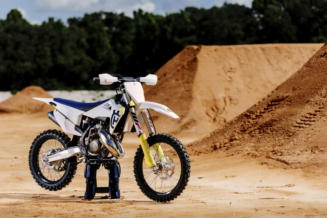 Nowy Husqvarna cross 125 gotowy na skok z piaskowej rampy.