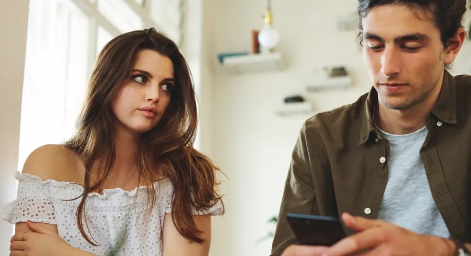 Osoba patrząca na telefon po randce z uśmiechem