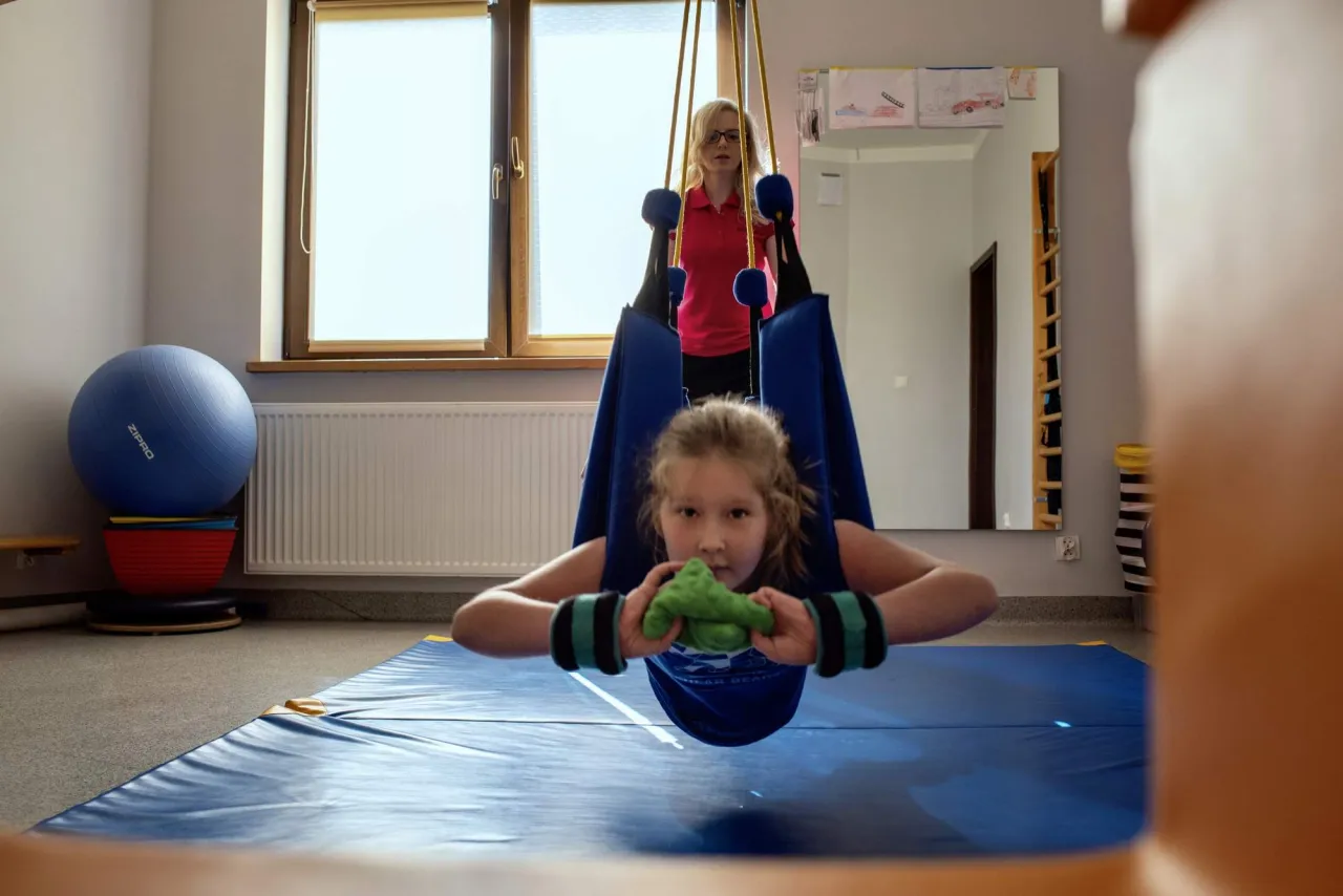 Dziecko na huśtawce terapeutycznej SI