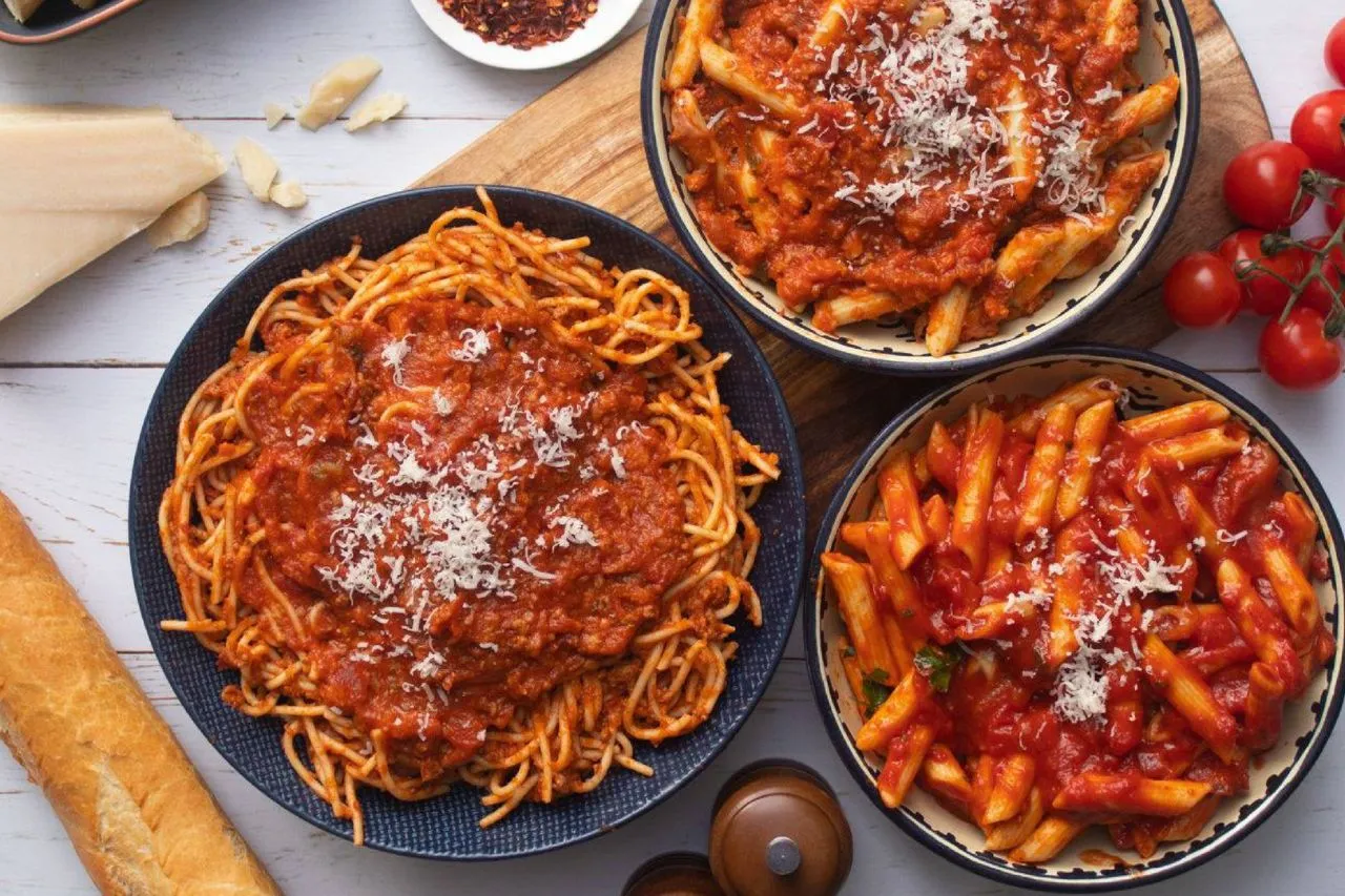 Pyszne spaghetti i penne z sosem pomidorowym, posypane parmezanem. Idealne co na obiad wegetariański!