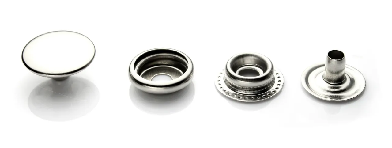 Metalowe zatrzaski, r&oacute;żne rodzaje zapięć w ubraniach: nap, oczko, gwint, trzpień.