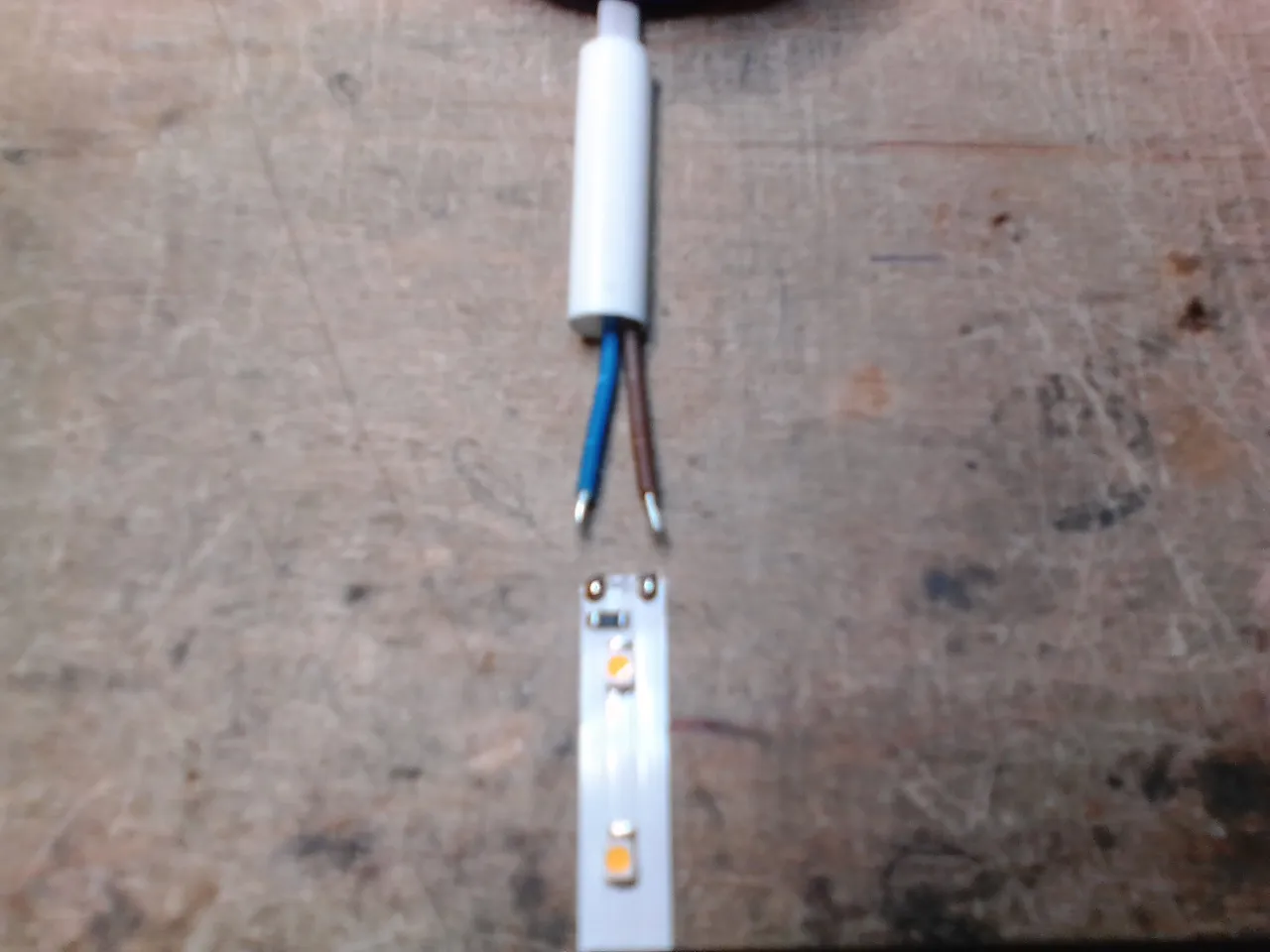 Przewody do oświetlenia schodowego: niebieski i brązowy kabel podłączone do taśmy LED.