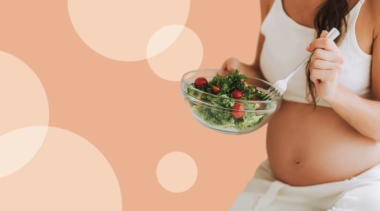 Kobieta w ciąży delikatnie dotykająca brzucha, uśmiechnięta, w tle naturalne światło