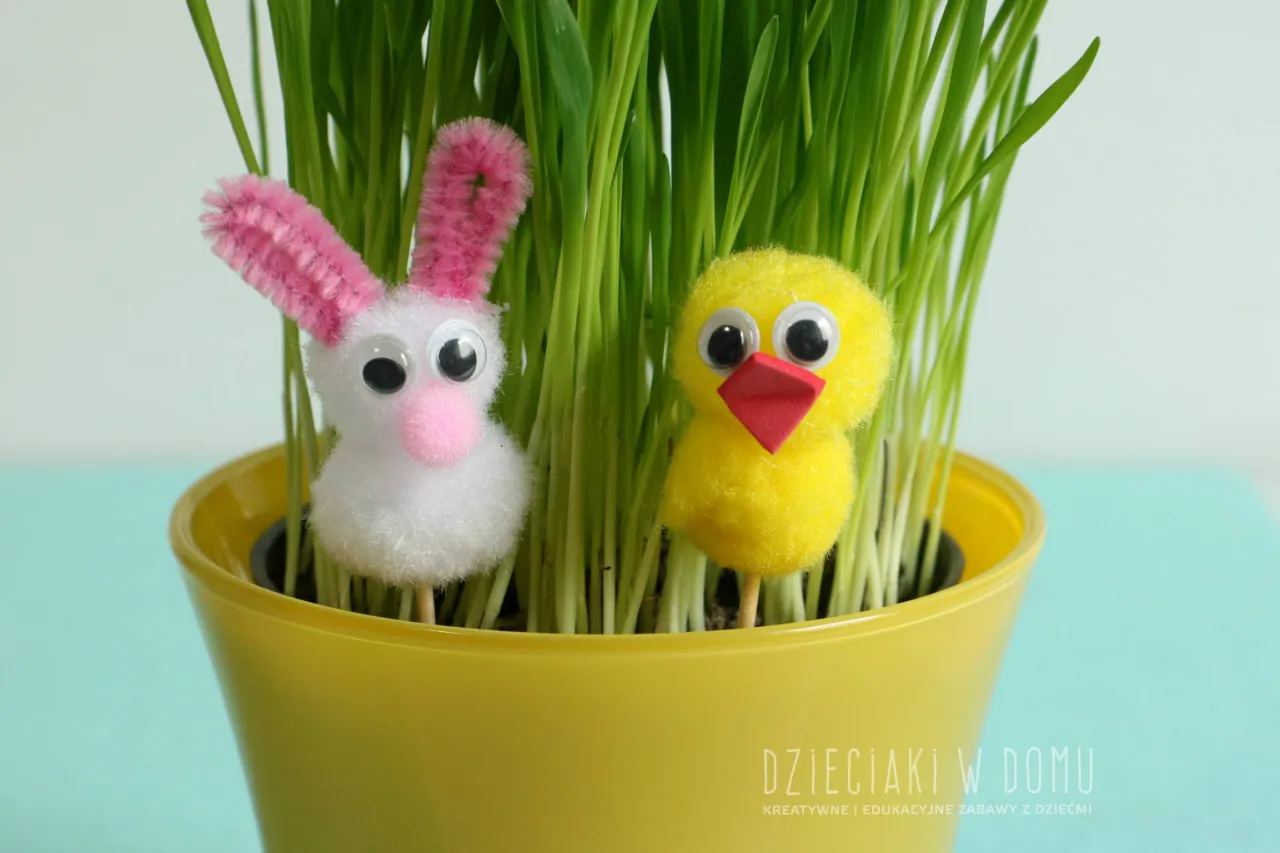 Urocze ozdoby wielkanocne z recyklingu: puchaty kr&oacute;liczek i ż&oacute;łty kurczaczek wśr&oacute;d zielonej trawki w ż&oacute;łtej doniczce.