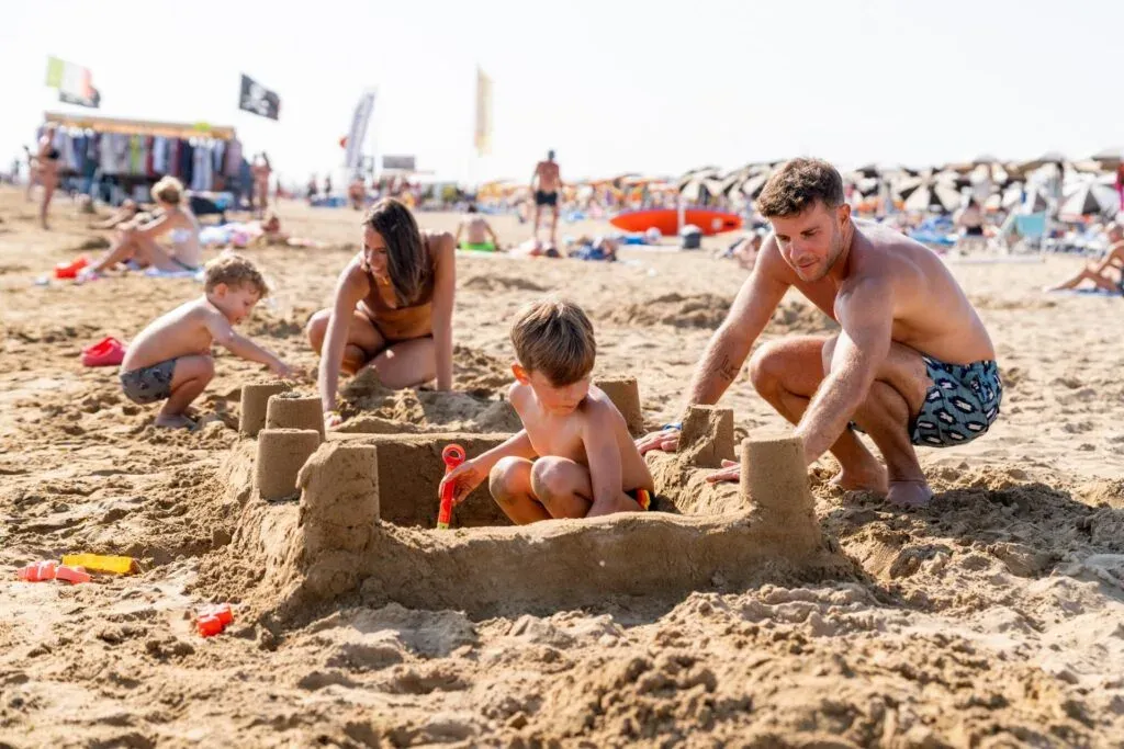 Rodzina z dziećmi na piaszczystej plaży Włochy