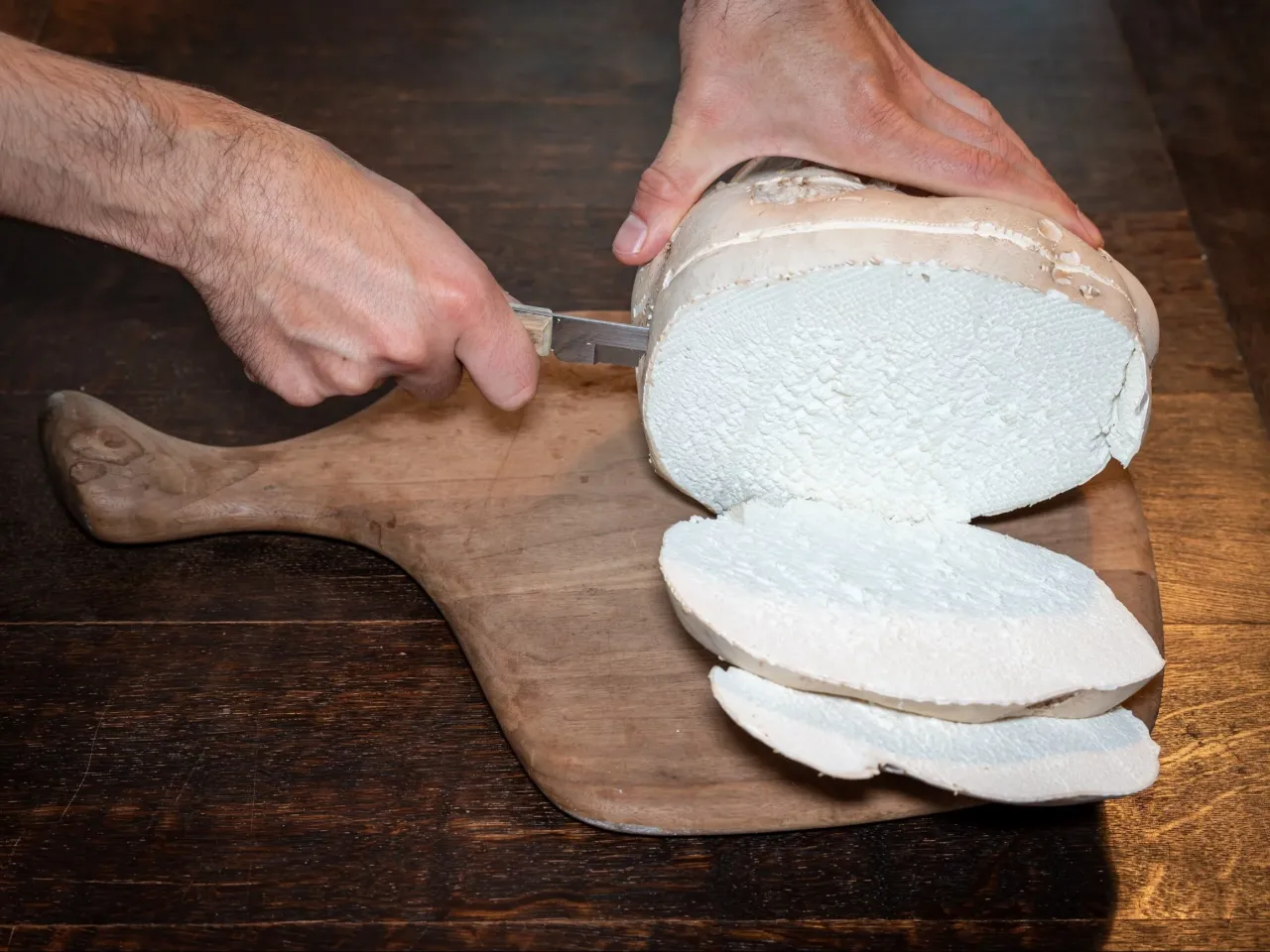 Krojona czasznica olbrzymia na desce. Jej biały, gąbczasty miąższ pokazuje ciekawe właściwości.