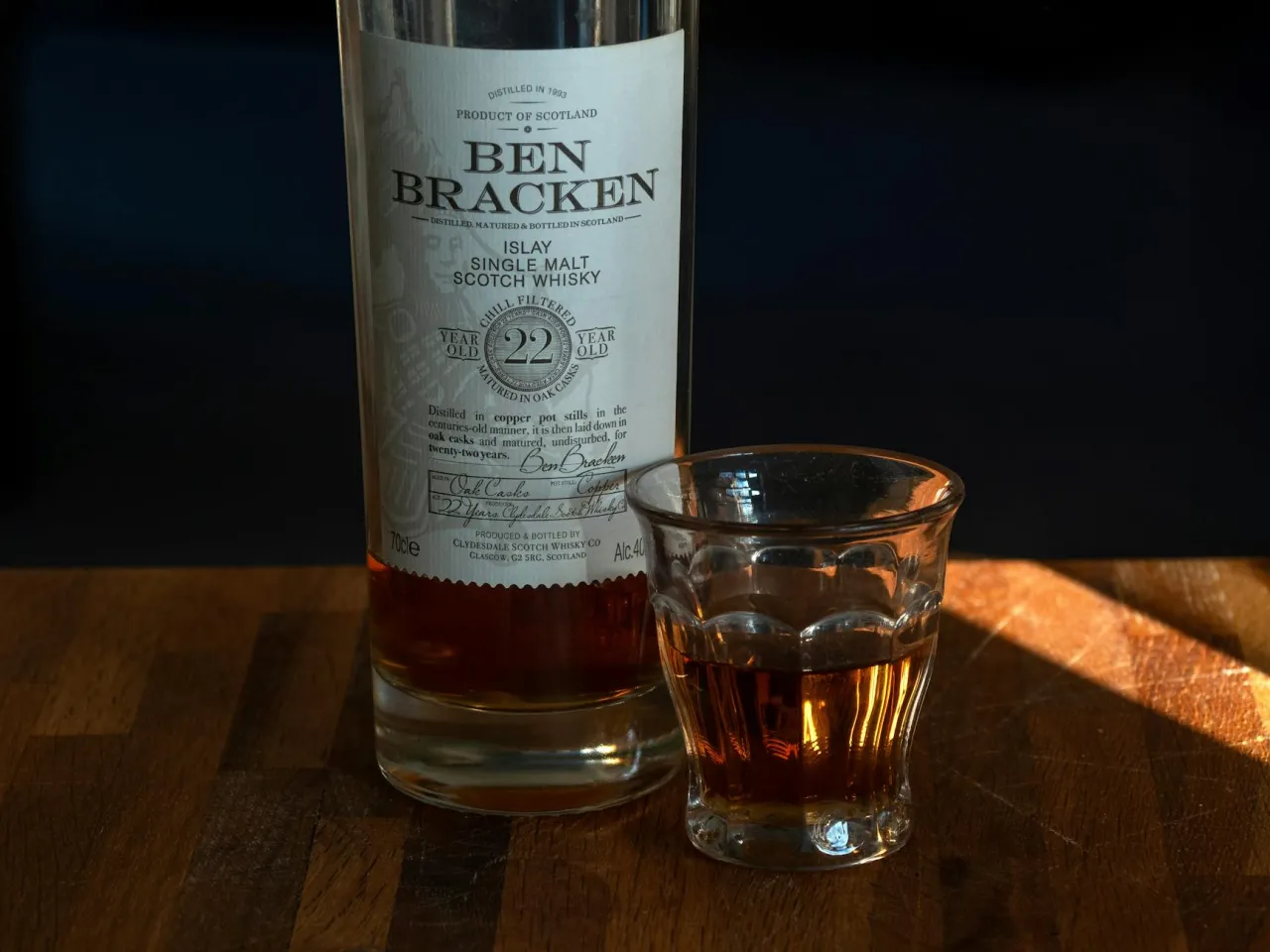 Butelka Ben Bracken 22yo i kieliszek z whisky. Jak degustować whisky żeby poczuć torf, wanilię i dym (metoda tulipana).
