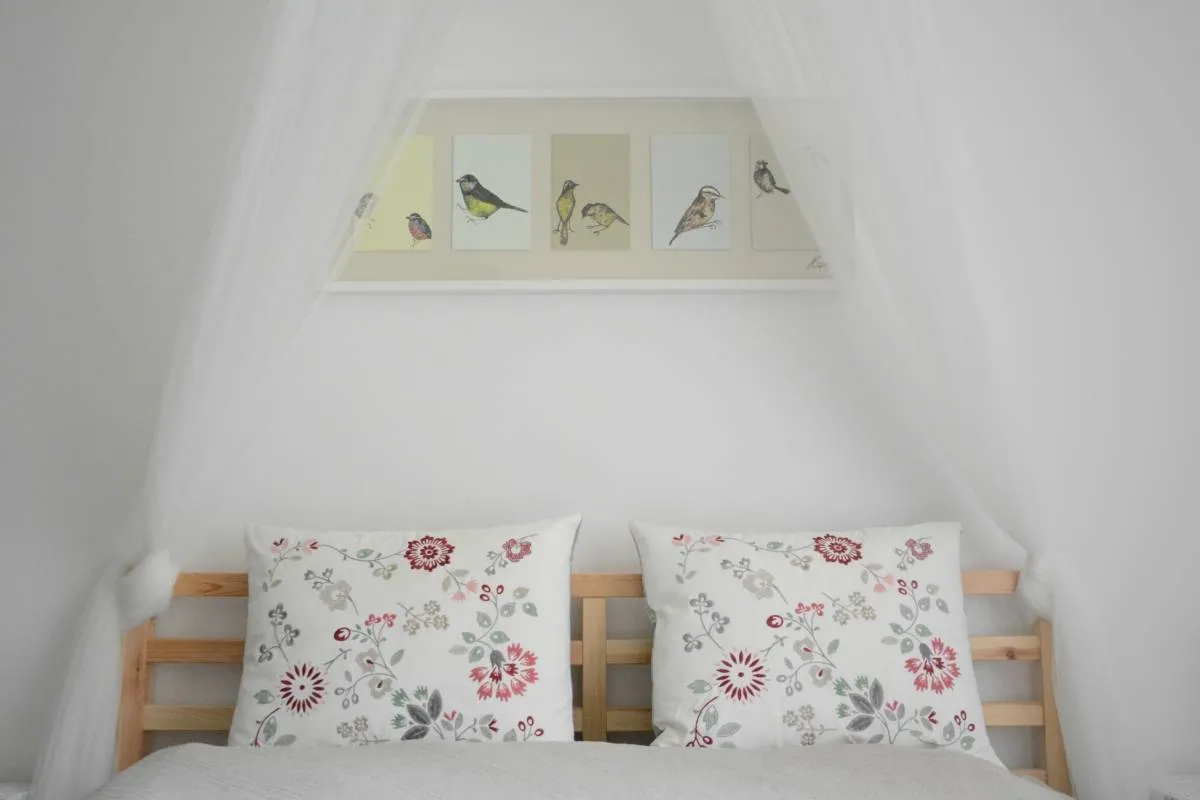 Delikatny stelaż do baldachimu nad łóżkiem, z subtelnym materiałem tworzącym przytulną atmosferę.