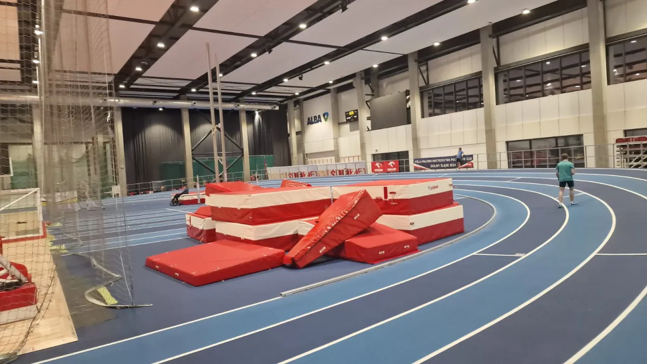 Na bieżni stadionu, gdzie zawodnicy przygotowują się do startu, widać stosy materacy do skoku wzwyż. Standardowa bieżnia ma 400 metrów.