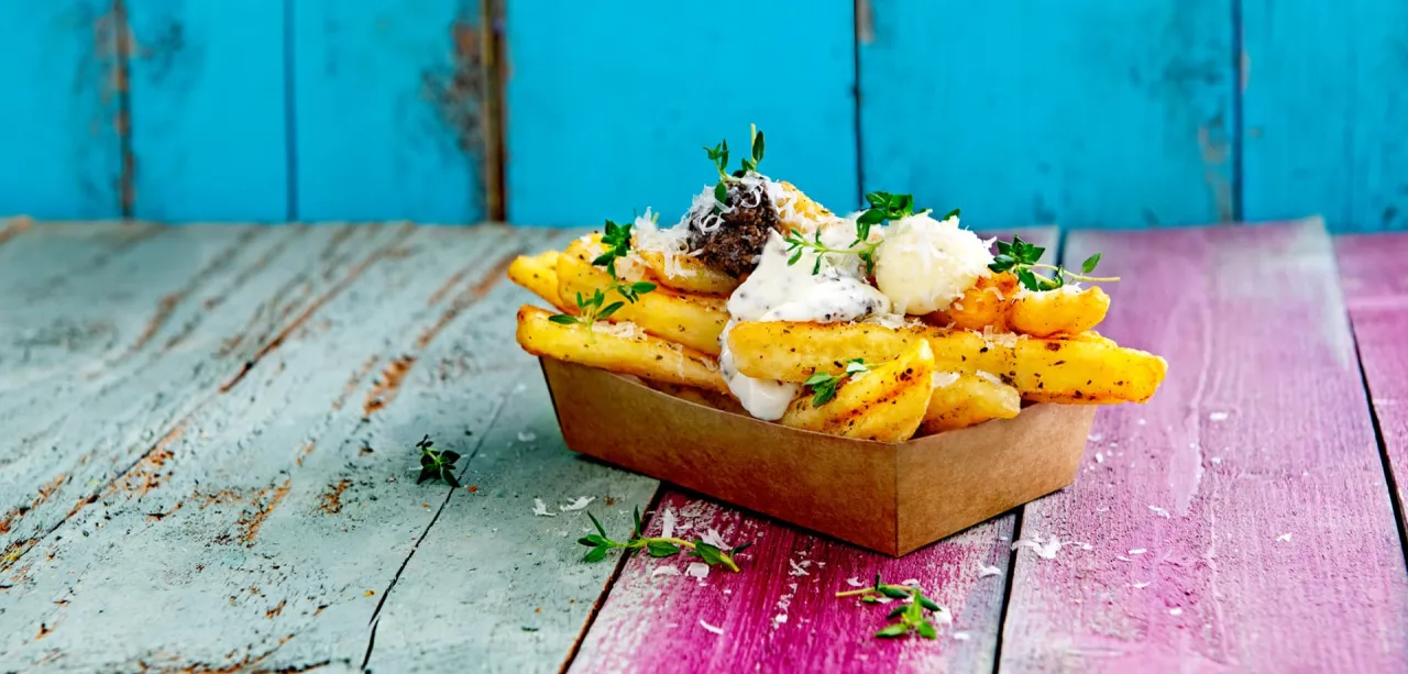 Złociste frytki z czymś pysznym: kremowym sosem, tartym parmezanem i ziołami. Idealne do podgryzania!