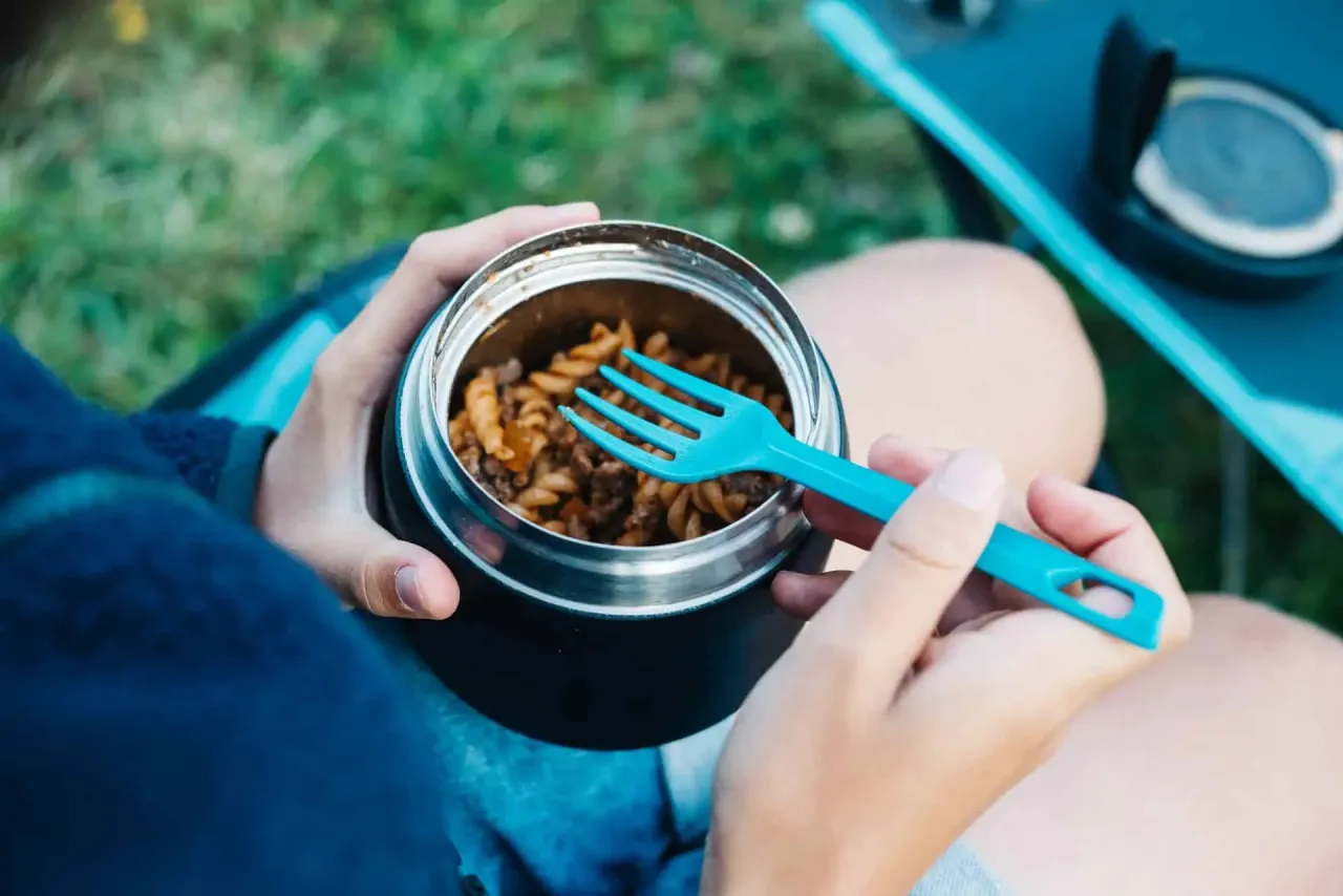 turysta pije wodę w górach