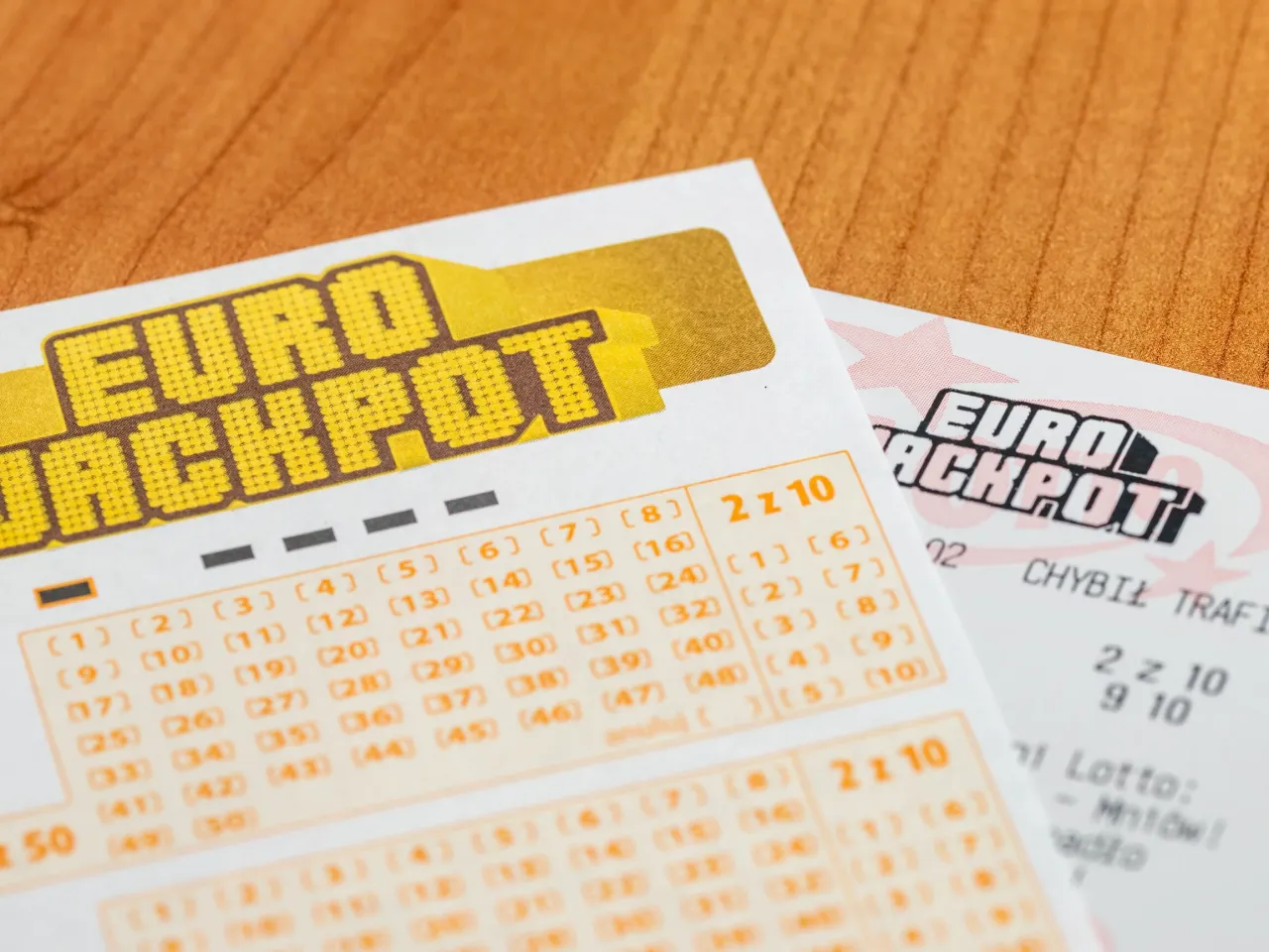 Kupony Eurojackpot leżą na drewnianym stole. Czy to właśnie te liczby przyniosą szczęście i wysokie wygrane? Sprawdźmy euro dzekpot wyniki!