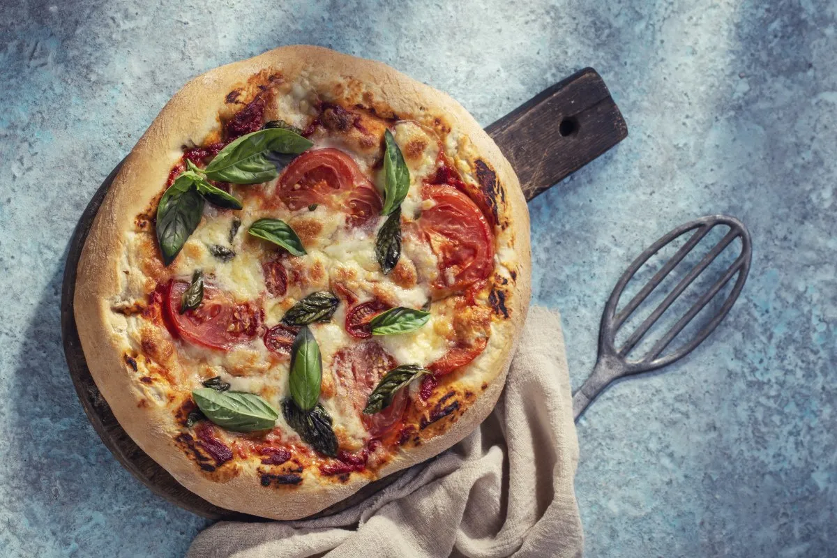 Pyszna pizza na cienkim cieście, z pomidorami i bazylią. Idealna, gdy zastanawiasz się, jak zrobić pizzę bez drożdży.