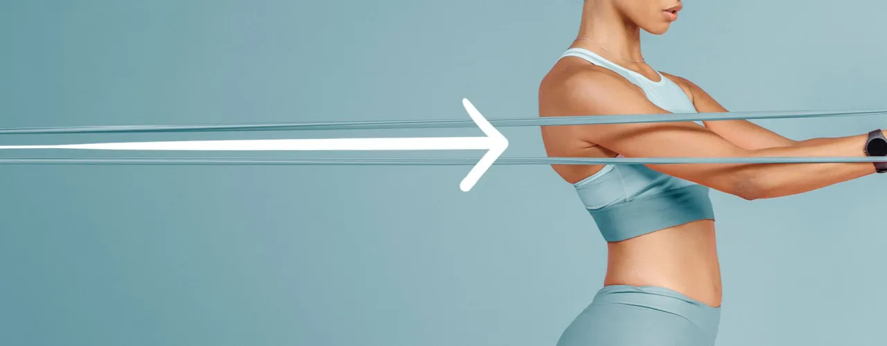 Kobieta wykonuje ćwiczenia z gumą, napinając mięśnie ramion. Strzałka symbolizuje postęp i siłę.