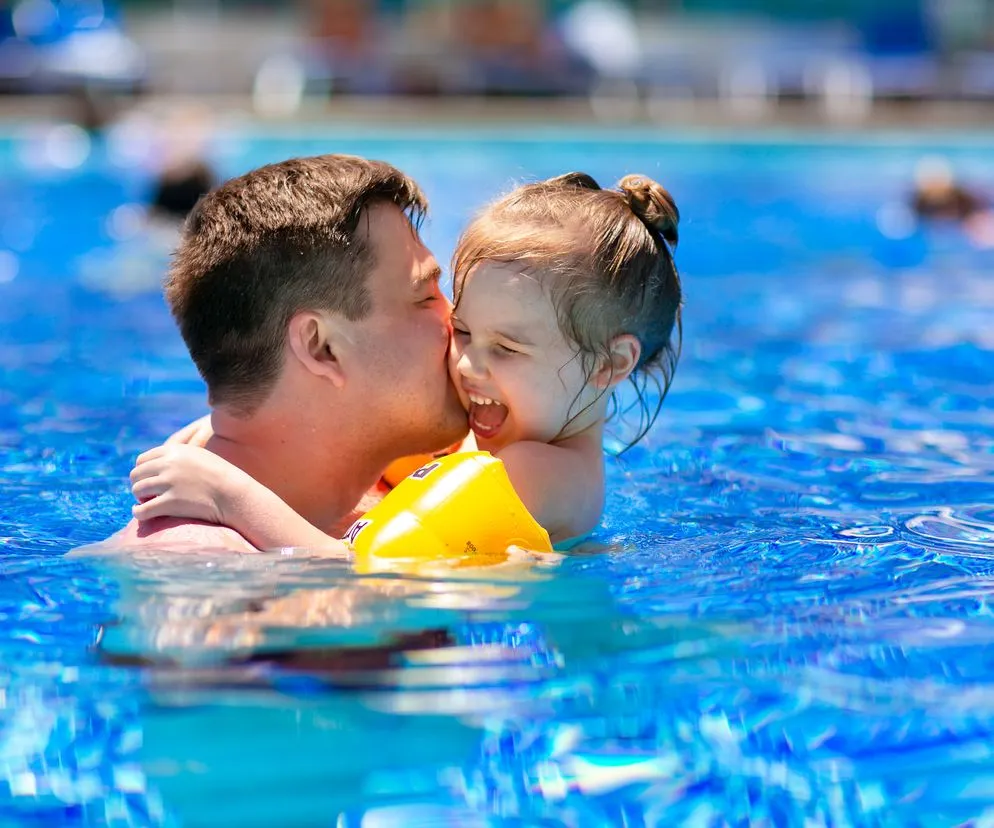 rodzic wspierający dziecko na basenie
