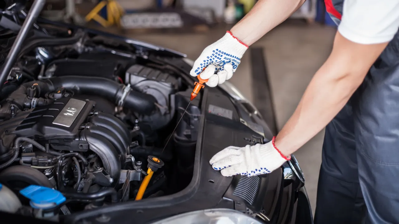 Mechanik sprawdza poziom oleju w nowym samochodzie. Regularna wymiana oleju to klucz do długowieczności silnika.