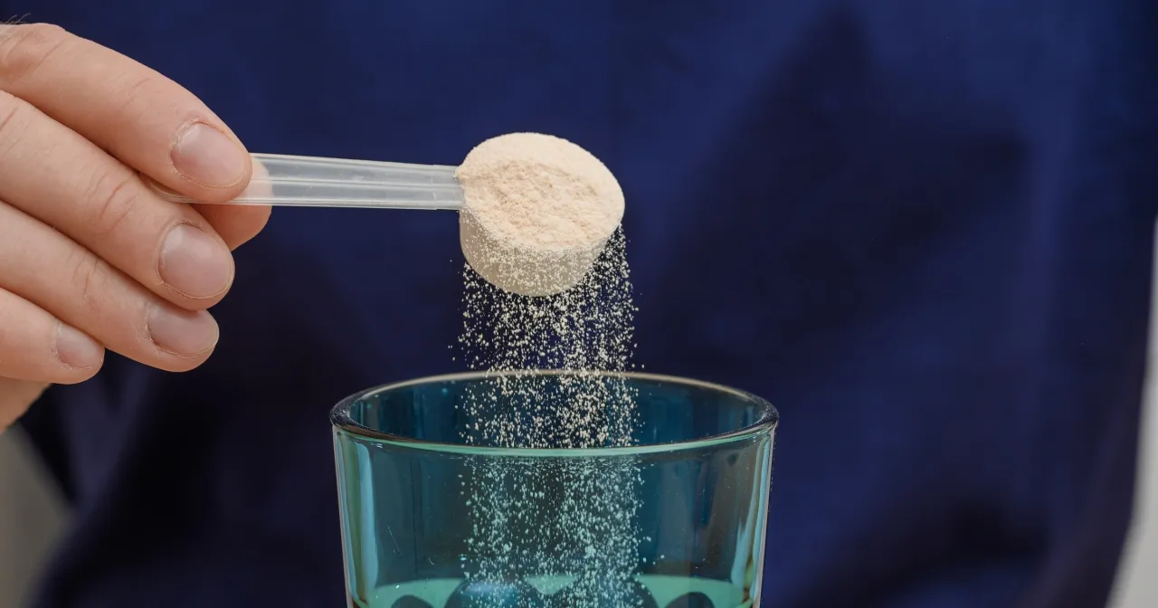 Łyżeczka z proszkiem wsypywana do szklanki wody. Czy elektrolity są zdrowe? To pytanie zadaje sobie wiele os&oacute;b.
