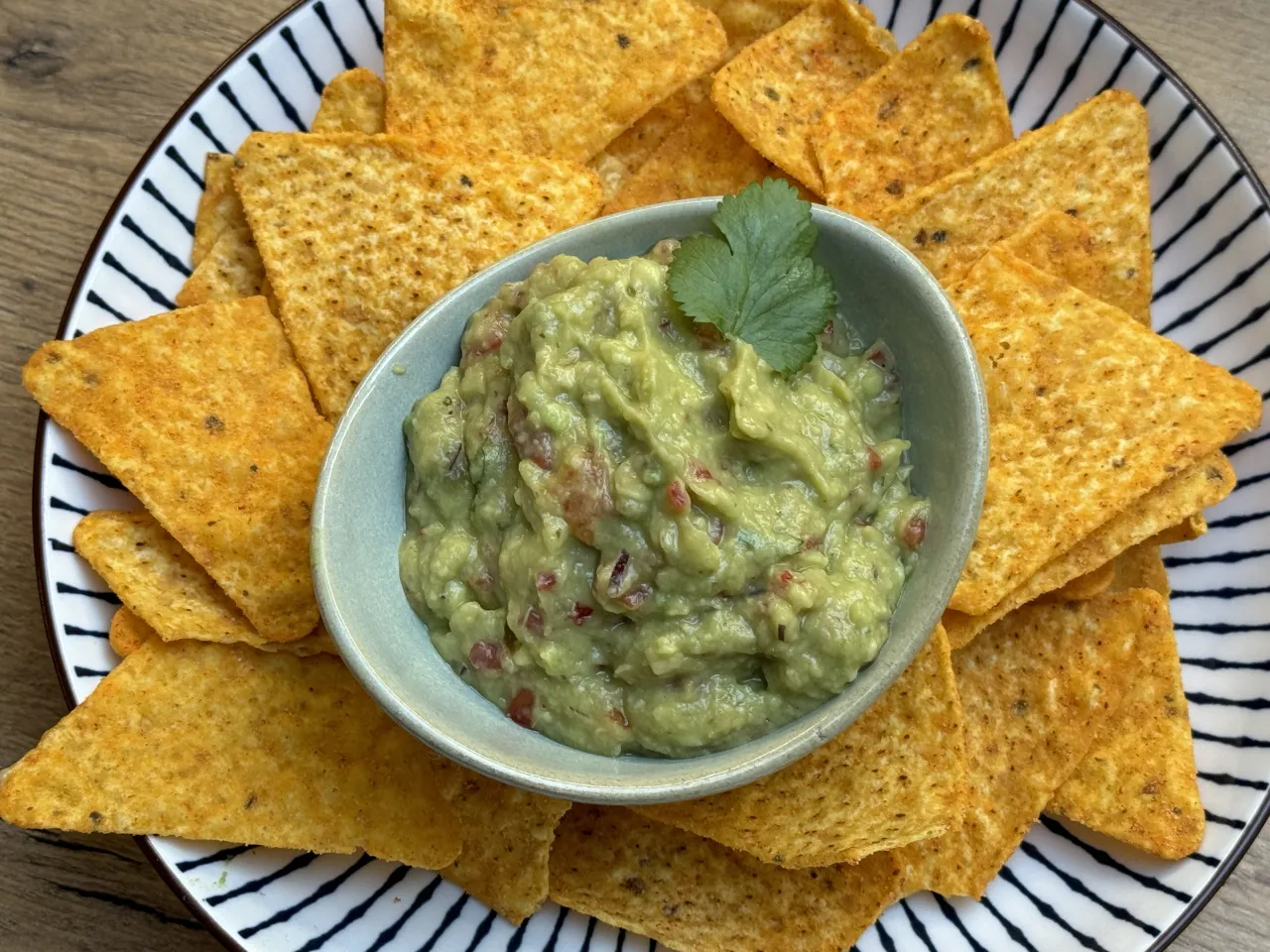 Jak zrobić guacamole na szybko? Pyszne, domowe guacamole z pomidorami i kolendrą, podane z chrupiącymi nachos. Idealna przekąska!