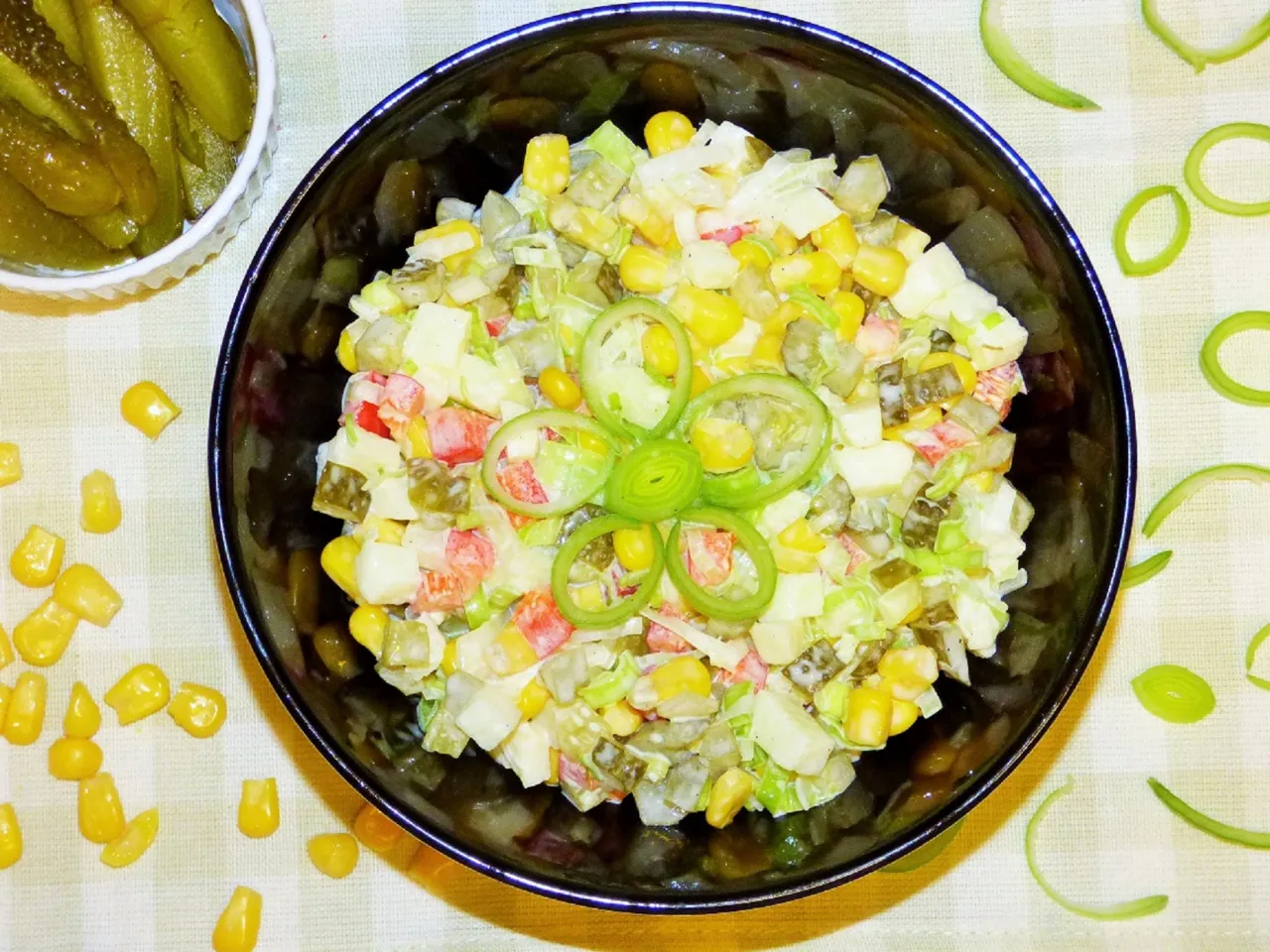 Kolorowa sałatka z pora, kukurydzy, og&oacute;rk&oacute;w i papryki, ozdobiona krążkami pora. Idealna na lato, oto jak zrobić sałatkę z por&oacute;w!