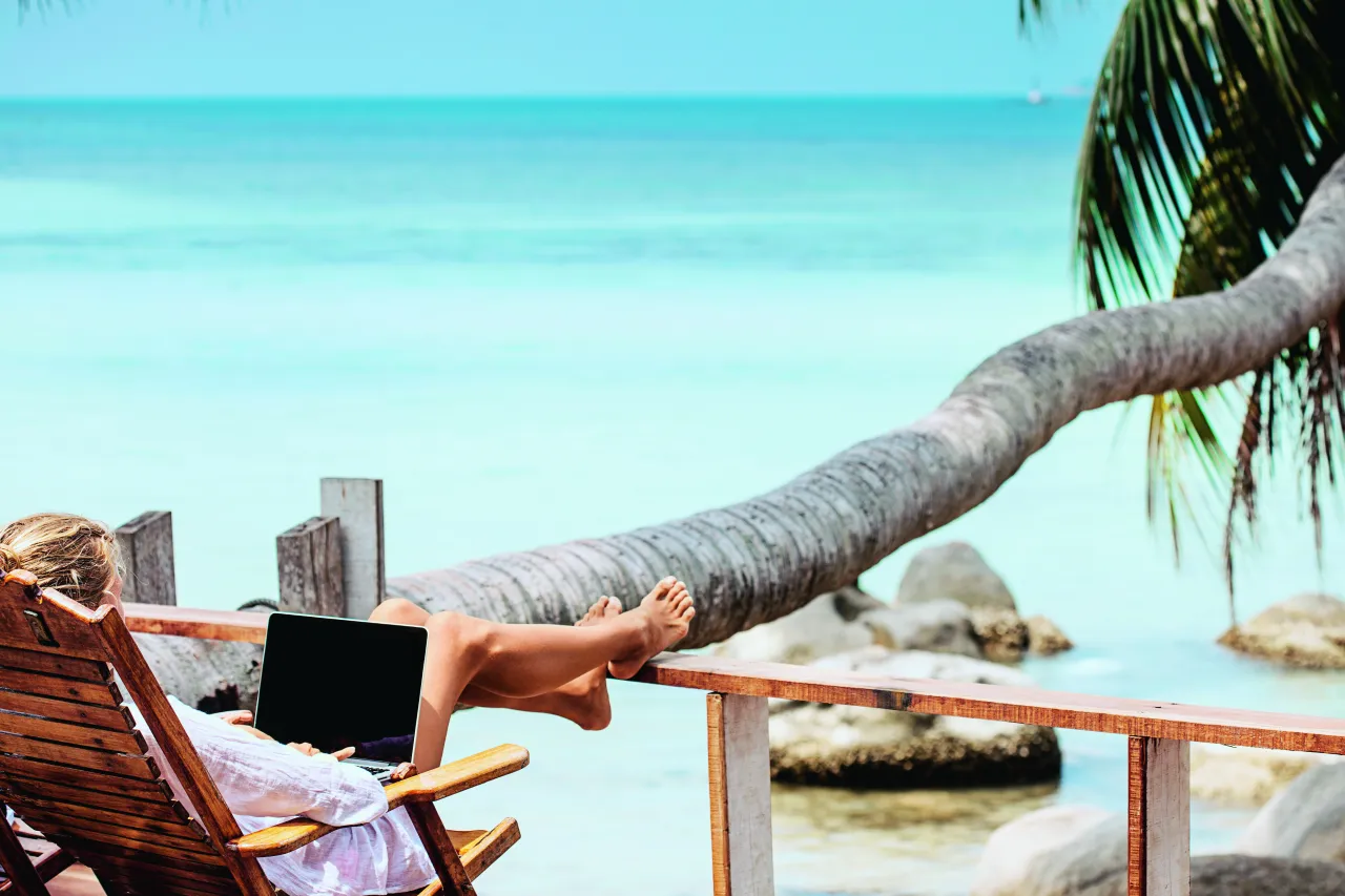 Praca zdalna na świecie, cyfrowy nomada, laptop na plaży