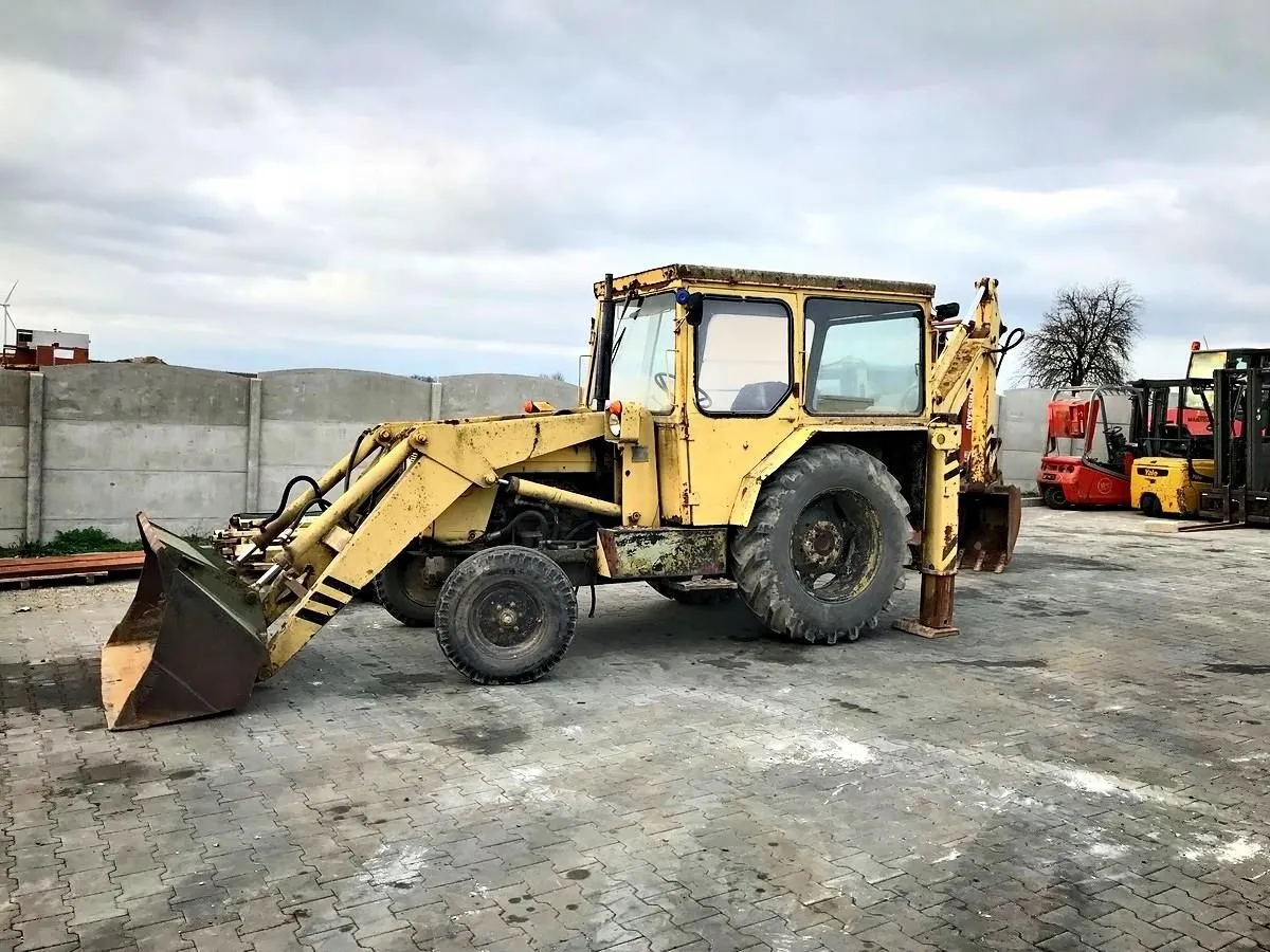 Żółta koparko-ładowarka Ostrówek. Zastanawiasz się, czy warto kupić koparkę Ostrówek? Ta maszyna czeka na nowe życie.