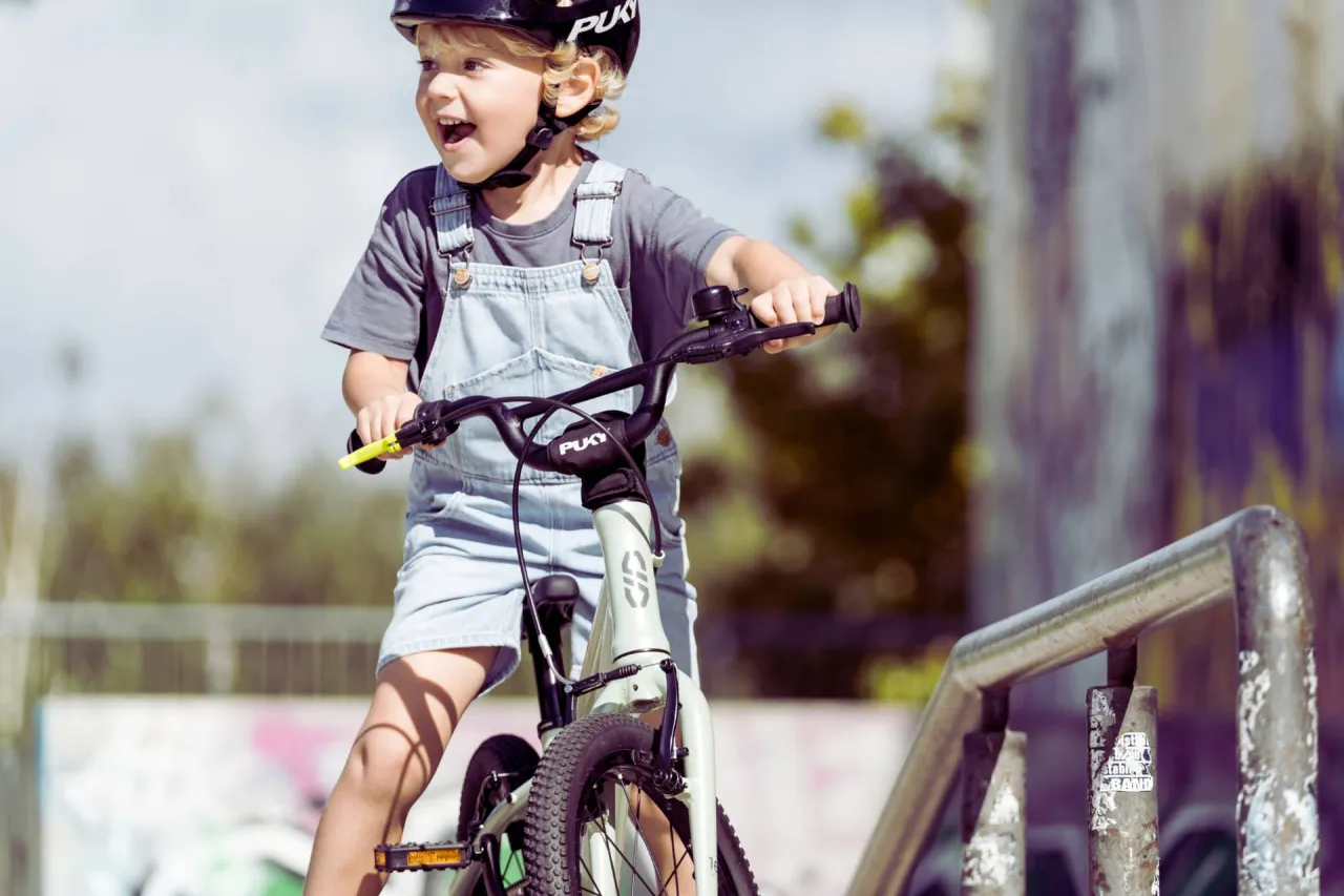 Kind mit Puky Fahrrad und Helm