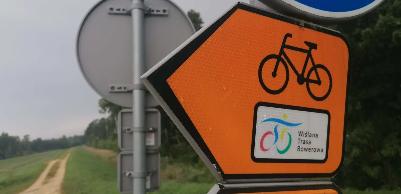 Pomarańczowy znak z rowerem i napisem 