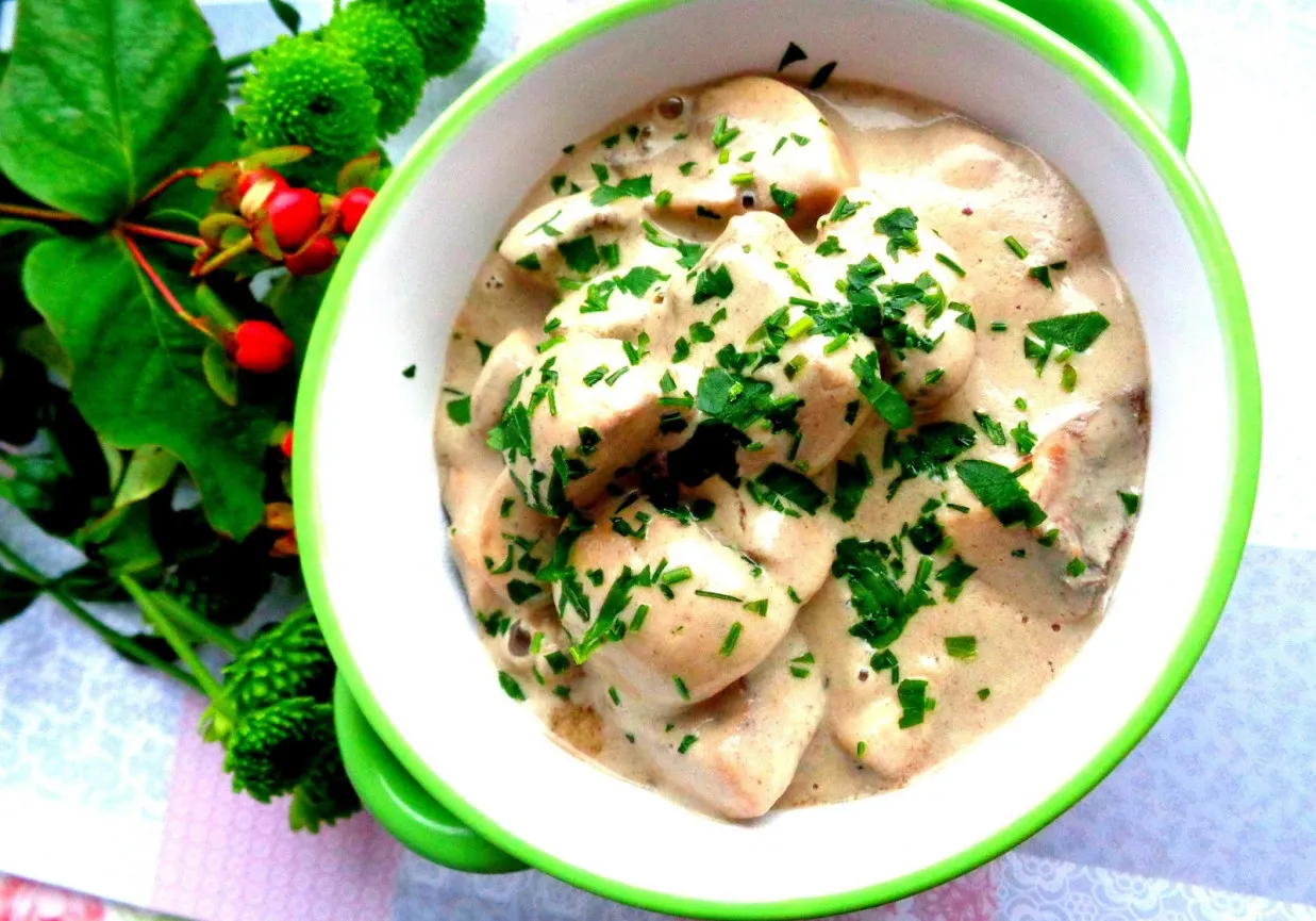 Kawałki kurczaka w kremowym sosie pieczarkowym, posypane natką pietruszki. Idealny dodatek do sosu pieczarkowego to świeże zioła.