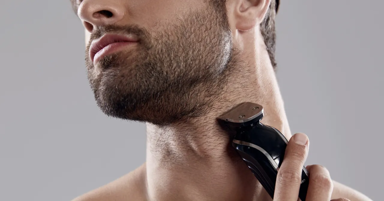 Mężczyzna golący się golarką elektryczną, zadowolony, bez podrażnień