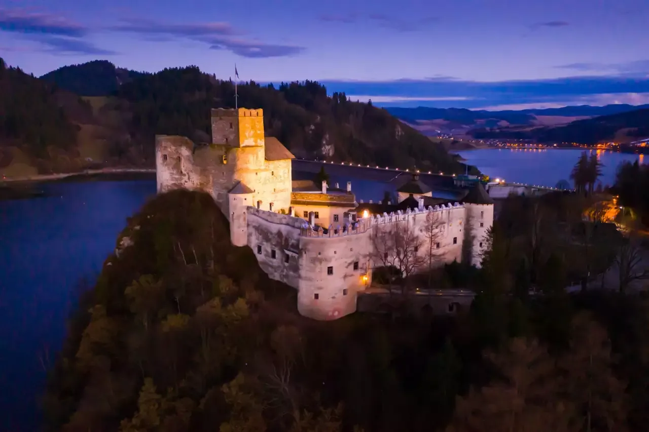 Zamek w Niedzicy o zmierzchu, idealne miejsce na odpoczynek po trasie rowerowej Velo Dunajec.