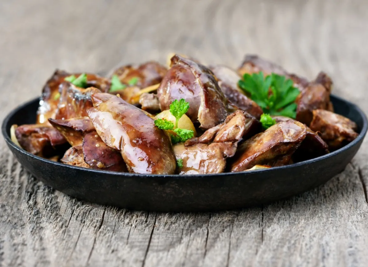 Smażona wątróbka z ziołami na czarnym talerzu. Czy wątróbka jest lekkostrawna? Zależy od sposobu przygotowania, ale ta wygląda apetycznie.