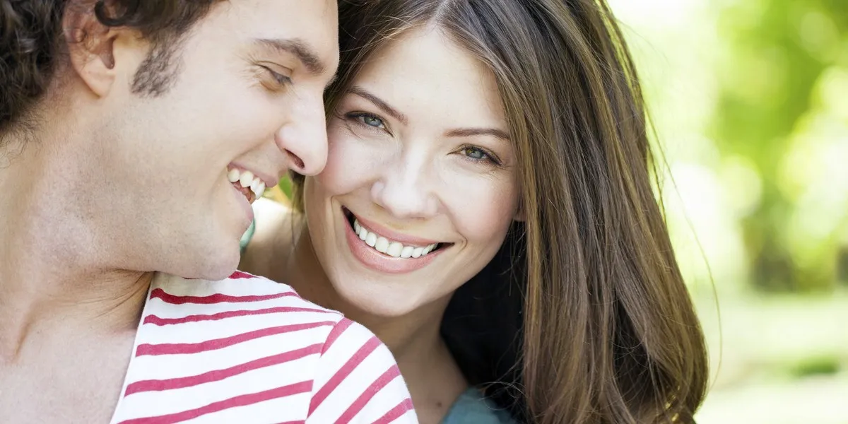 Kobieta aktywnie słuchająca mężczyzny, z uwagą i uśmiechem