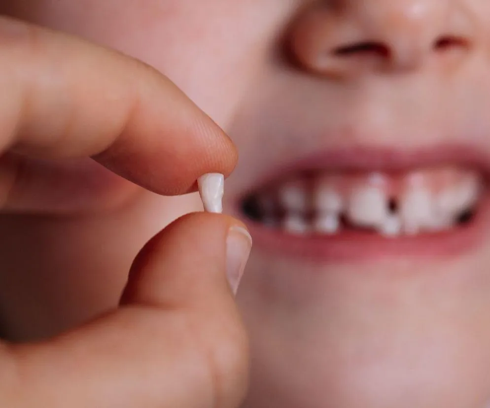 dziecko samodzielnie wyjmujące ruszający się ząb mleczny